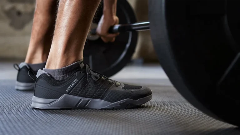 Man's feet wearing hylete sneakers and lifting weights